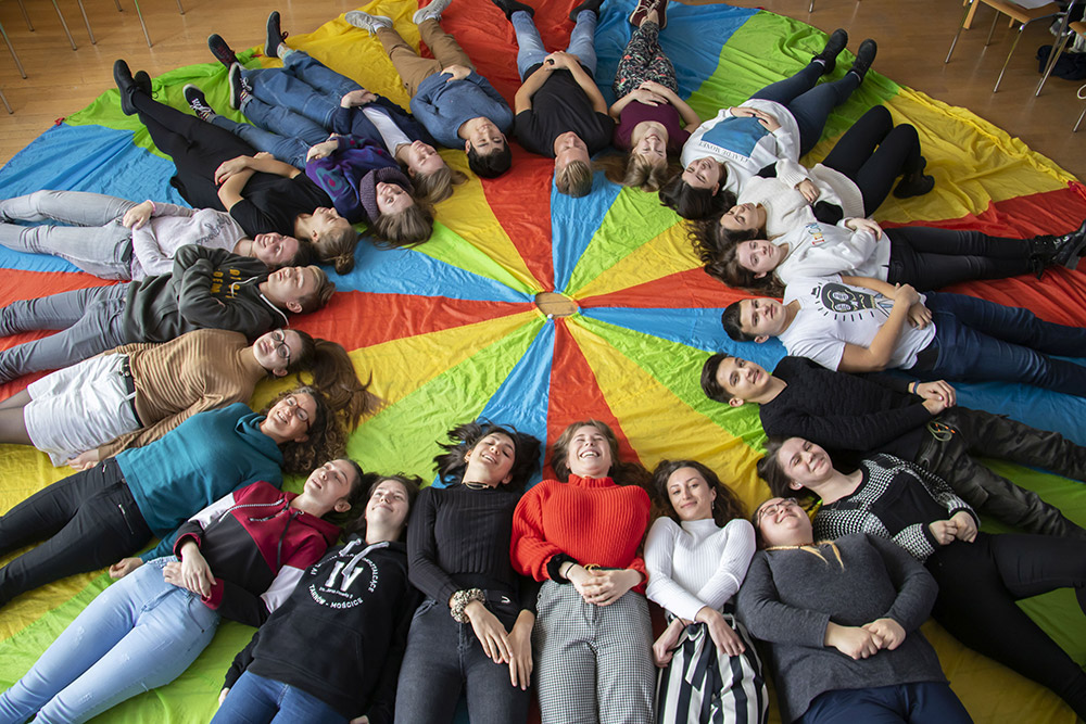 jugendliche_liegen_auf_tuch_und_bilden_einen_kreis_-_stiftung_kinderdorf_pestalozzi