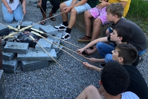 kinder_machen_schlangenbrot_am_lagerfeuer_ferienlager_action_fun_schweiz_stiftung_kinderdorf_pestalozzi_website