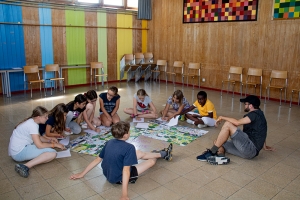 kinder_sitzen_im_kreis_und_sprechen_ueber_kinderrechte_ferienlager_kunterbunt_schweiz_stiftung_kinderdorf_pestalozzi