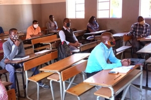 lehrer_sitzen_mit_maske_im_schulzimmer_-_stiftung_kinderdorf_pestalozzi